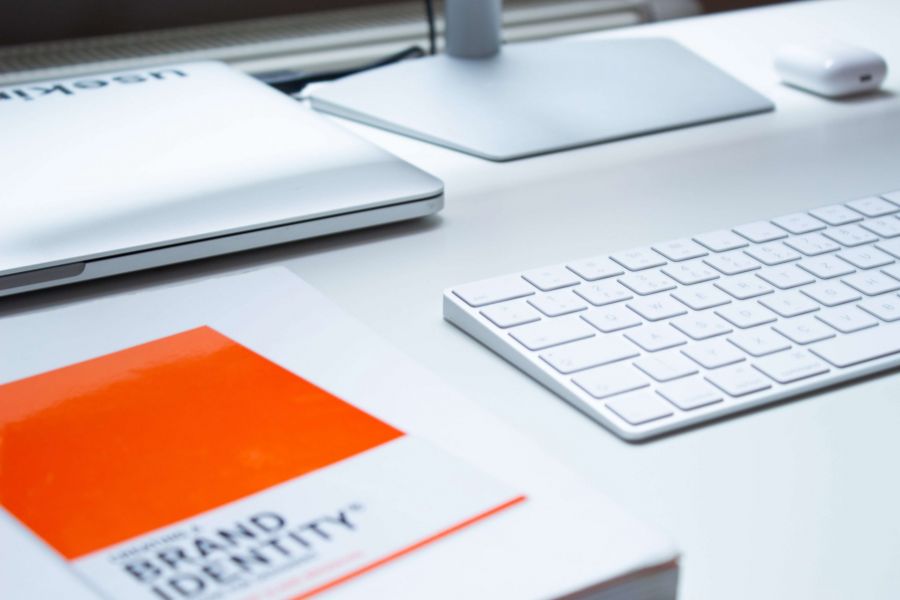 book on a desk next to apple keyboard